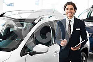 Salesman Selling Car Standing In Dealership Center