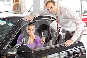 Salesman selling a car to happy customer