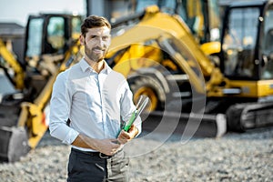 Salesman at the shop with heavy machinery