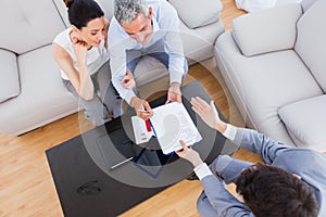 Salesman showing contract to couple who are about to sign