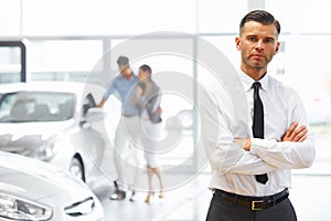 Salesman standing in car retail store. Car Showroom.