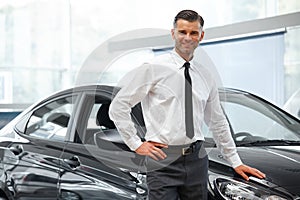 Salesman Stands Near Brand New Car. Car Showroom