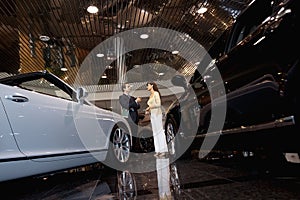 Salesman talking to woman in automobile showroom