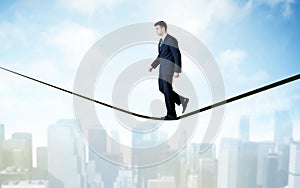 Salesman walking on rope above the city photo
