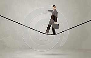 Salesman walking on rope in grey space