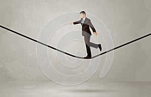 Salesman walking on rope in grey space