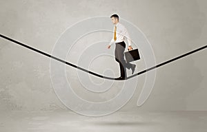 Salesman walking on rope in grey space