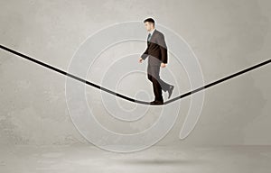 Salesman walking on rope in grey space