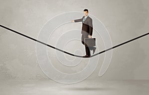 Salesman walking on rope in grey space