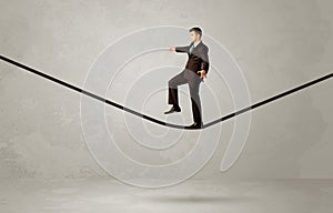 Salesman walking on rope in grey space