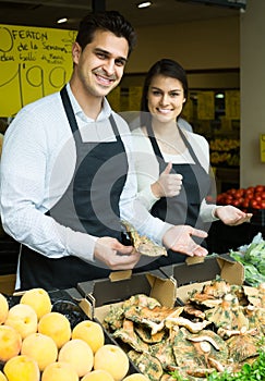 Salespeople with farm mushrooms in market photo