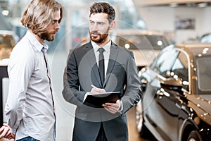 Salesperson with client in the car showroom