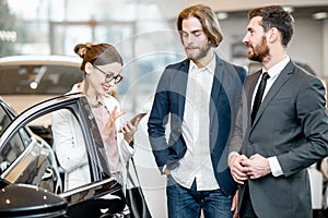 Salesperson with couple in the car showroom