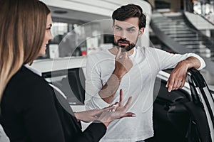 Salesperson with customer in car dealership