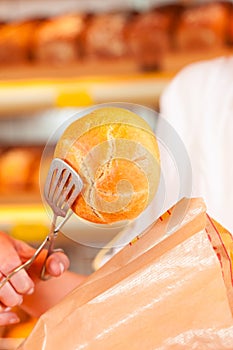 Salesperson is packing bread in bakery