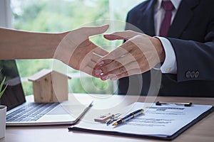 The salesperson shake hands with the landlord after negotiating a living agreement