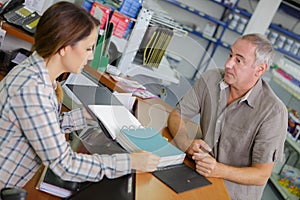 Saleswoman and client at cash counter in hardware store