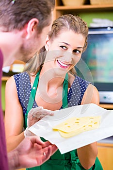 Saleswoman at counter offering cheese photo