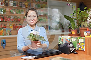 Saleswoman with flower at garden store