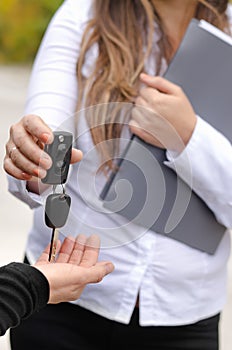 Saleswoman handing over the keys to a car