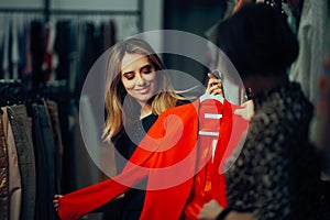 Saleswoman Presenting a Blazer to her Fashion Store Customer