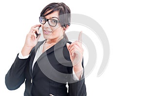 Saleswoman talking on the phone and making wait gesture