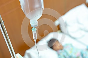 Saline intravenous iv drip in a children`s patient hand, kid sick and sleep and equipment IV tube of Infusion pumps for patients