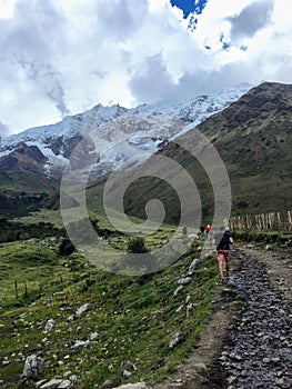 A young group of international hikers, led by their local Inca guide, navigate the Andes mountains on the Salkantay Trail