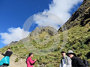 A young group of international hikers, led by their local Inca guide, navigate the Andes mountains on the Salkantay Trail