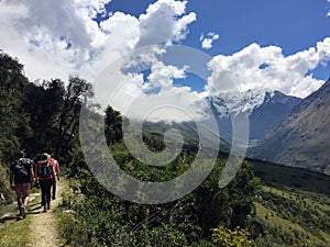 A young group of international hikers, led by their local Inca guide, navigate the Andes mountains on the Salkantay Trail