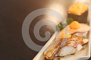Salmon aburi nigiri and gunkan sushi with ebiko sauce.