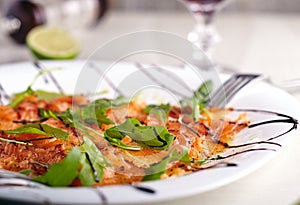 Salmon carpacho in white plate