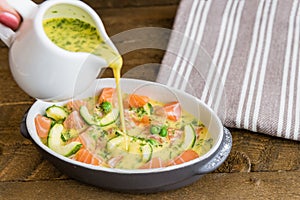 Salmon clafoutis cooking. Wooden background