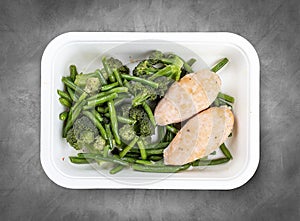 Salmon cutlets with broccoli and green beans. Healthy food. Takeaway food. Top view, on a gray background