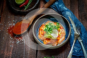 Salmon fillet ceviche with marinated, green, parsley, onion on blue plate