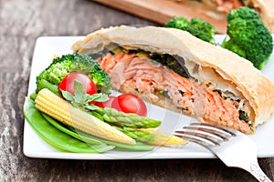 Salmon fillet on leek and spinach baked in puff pastry