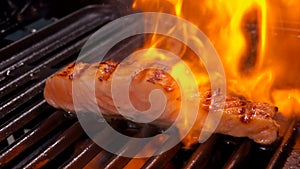 Salmon fillet steak is grilled on an open fire.