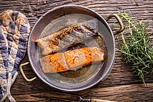 Salmon fillets. Grilled salmon, sesame seeds herb decorationon on vintage pan or black slate board.