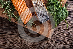 Salmon fillets. Grilled salmon, sesame seeds herb decorationon on vintage pan or black slate board.