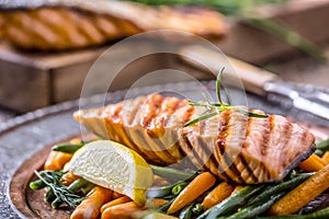 Salmon fillets. Grilled salmon, sesame seeds herb decorationon on vintage pan or black slate board.