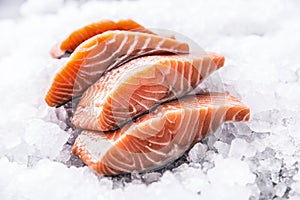 Salmon fillets portioned on ice and empty kitchen board