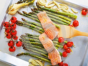 Salmon fish and green aspargus, cherry tomatoes and fennel