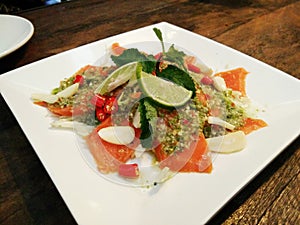 Salmon fish seafood sashimi mix with hot spicy chili sour lemon lime juice in Thai style