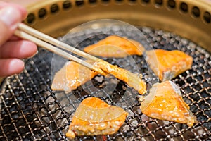 Salmon fish steak cooking over charcoal grill.