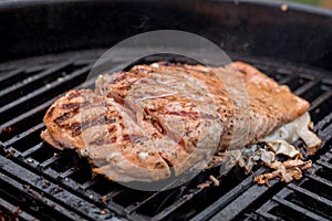 Salmon on the grill freshly seasoned and cut to check photo