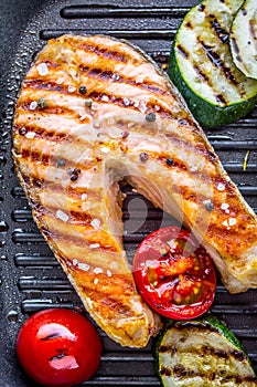 Salmon. Grilled fish salmon. Grilled salmon steak in grill pan on rustic wooden table