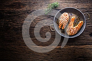 Salmon. Grilled fish salmon. Grilled salmon steak in roasted pan on rustic wooden table