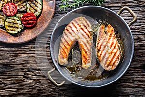 Salmon. Grilled fish salmon. Grilled salmon steak in roasted pan on rustic wooden table