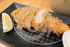 Salmon katsu like a famous pork cutlet Tonkatsu on black plate