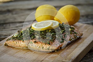 Salmon with lemon and dill on cutting board